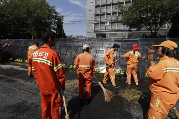 Công nhân vệ sinh đang dọn dẹp trước đại sứ quán Nhật Bản tại Bắc Kinh (Ảnh: AP)
